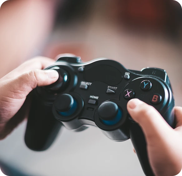 Uma visão aproximada de mãos usando um controle de jogo preto. A imagem destaca a jogabilidade ativa e a interação do jogador.